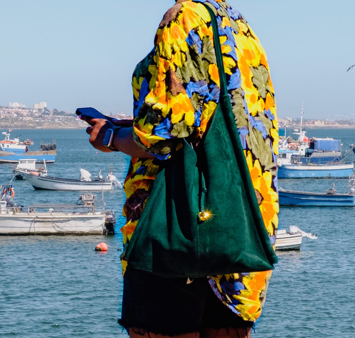 Green leather shopper bag from ZARA styled with a colourful shirt by the seaside
